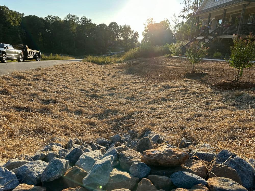 Dry landscape featuring stones in the foreground and a sunset in the background.